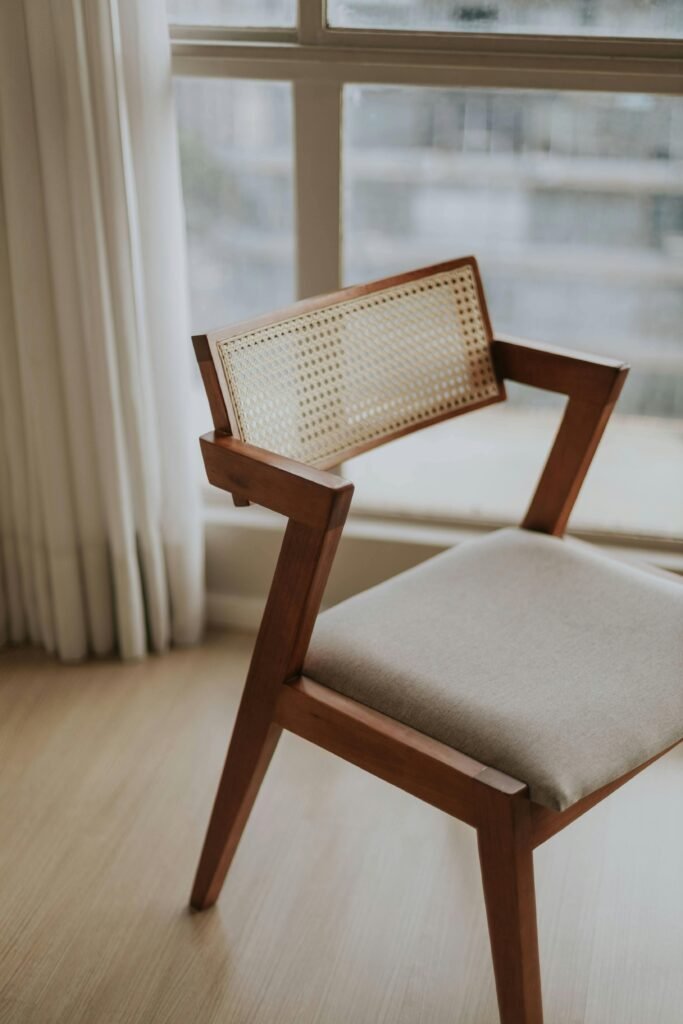 Stylish mid-century modern wooden chair with fabric seat in a bright sunlit room.